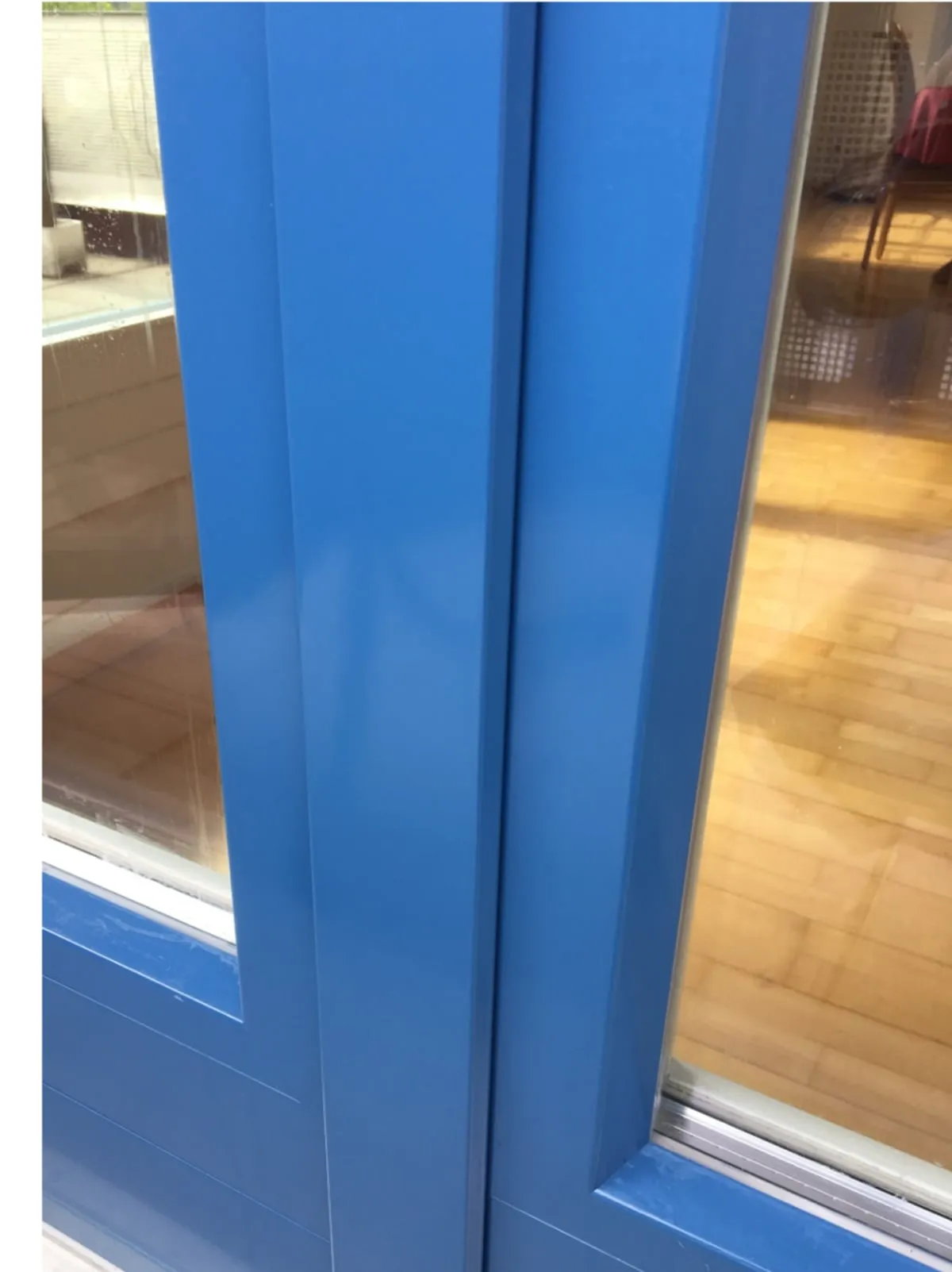 Derselbe Fensterflügel nach der Montage von Flügelmetall, glatte blaue Metalloberfläche