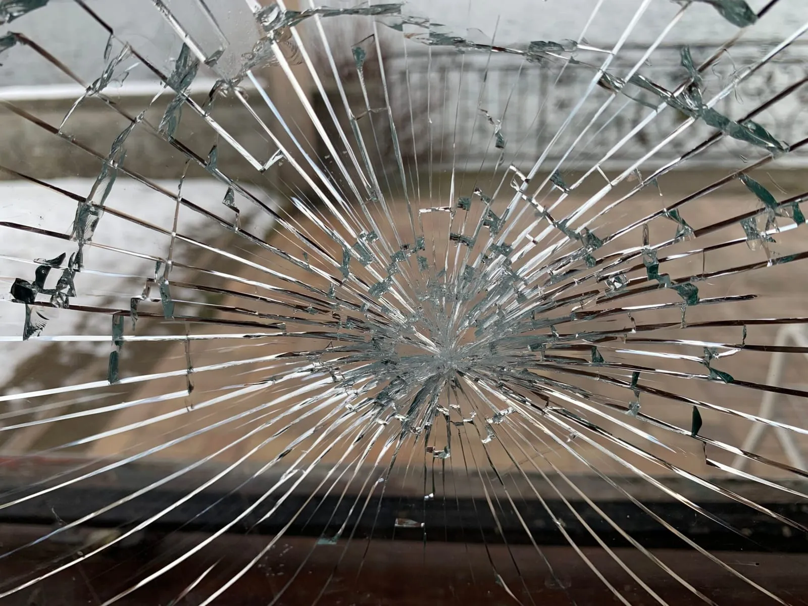 Nahaufnahme einer gesprungenen Fensterscheibe mit sternförmigem Bruchbild